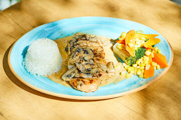 Fried fish with rice and vegetables on blue plate