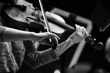 Hands of a musician playing the violin in black and white