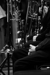 Trombones in the hands of musicians in the orchestra in black and white
