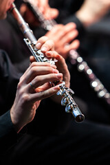 Hands of a musician playing the flute close up