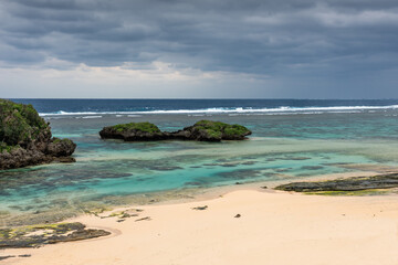 Hoshizuna beach in winter day, gray clouds and polarized transparent sea. Iriomote Island.