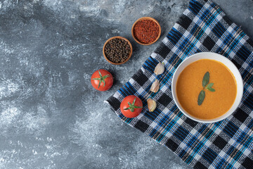 A white bowl of lentil soup with vegetables on a beautiful tablecloth