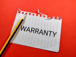 Selective focus.Word WARRANTY on notepaper with pencil on red background.Insurance concept.