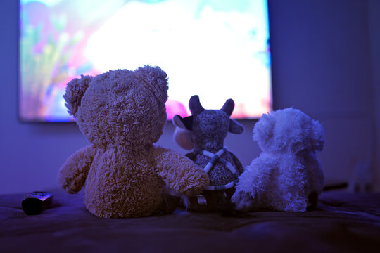 baby toy watching movies, sitting on the blur background of tv
