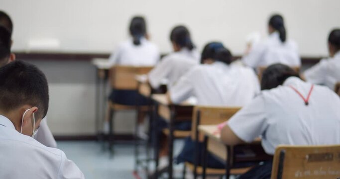 Asian high school students in white school uniform are serious and tired of exams.	
