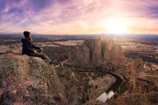 Man enjoying the Beautiful American Mountain Landscape. Dramatic Colorful Sunset Sky Art Render. Taken in Smith Rock, Redmond, Oregon, America. Concept: Adventure, Holiday and Travel