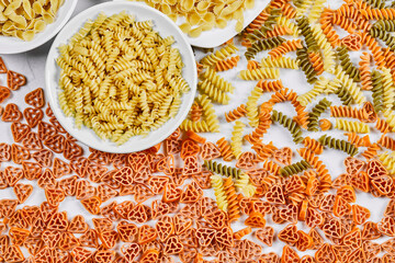 Various uncooked pasta on white background