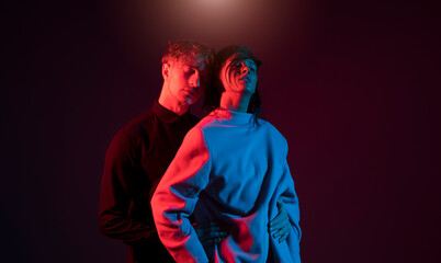 Beautiful man with his hot girlfriend is in the studio. Neon. Couple love. 