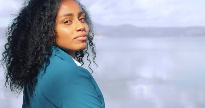 youth, confidence - hispanic firl looking at lake turns and smiles at camera
