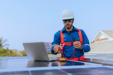 An Engineer use a laptop computer to inspection the solar panels at roof top