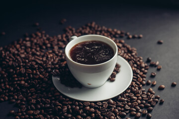 coffee beans and a cup on a white saucer dark background drink