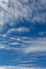 Clear blue sky with clouds and sunbeams. Space for the test. Background. Verical.