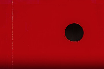 Red metal background with dark circle