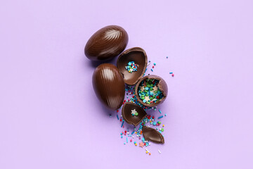 Composition with chocolate Easter eggs on color background