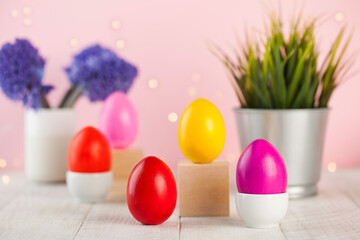 Fototapeta na wymiar Easter colorful eggs on the background of spring flowers. Bright Easter concept. Copy space.