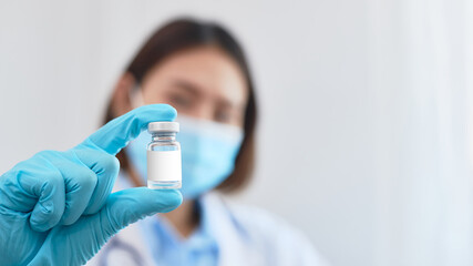 A woman doctor with a vaccine bottle.