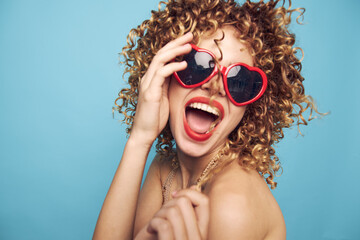 Cheerful woman emotions laughter red heart glasses bright makeup blue background