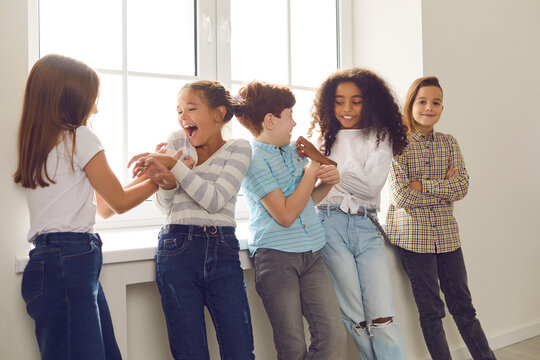 Group Of Happy Diverse Friends Playing, Tickling Each Other, Laughing, Having Fun During School Recess Or Party At Home. Children's Social Interaction With Peers, Intercultural Kids Community Concepts