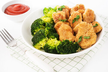 Chicken nuggets with vegetables, broccoli and ketchup on a white background