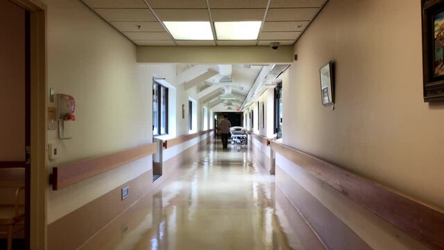 Bright hospital corridor view with people walks through a hall