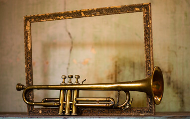 an ancient jazz trumpet and a frame