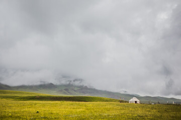 Fototapeta premium Yurt. National ancient home of Asian countries. National housing. Yurts on the background of a green meadow and mountains. View of the nomads' yurts. Traditional yurts (geras), Mongolian nomads.