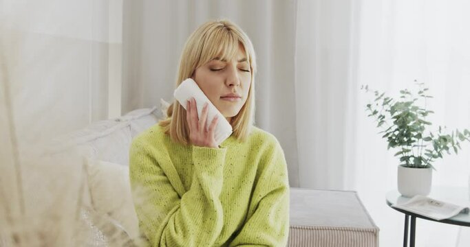 Toothache. Young woman compresses a aching tooth.