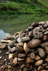 Fototapeta na wymiar Pile of rocks along na river bank