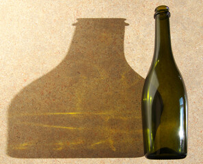Large shadow on the table from a glass bottle. The light from the window falls on the bottle.