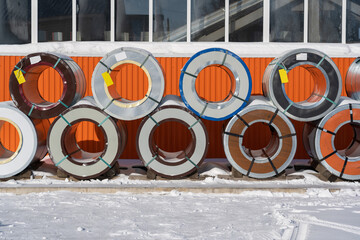 Pallets with rolls of sheet metal in the open air in winter