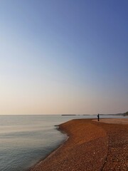 Landscape sea view with beautiful sunset sky and one man stand on beach.