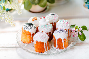 Religious food. Group of decorated Easter cakes on a platter with apple blossom and branch of cherry. In the background-plants and flowers. Top view. Easter holiday