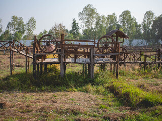 Cart wheels and wooden walkways at temple called "Wat Pipat Mongkol" or "The golden buddha's Building", Thungsaliam, Sukhothai, Thailand in 26 February 2021.