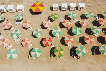 people under umbrellas on the beach top view