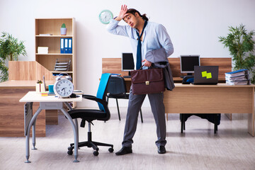 Young male employee being late for his job