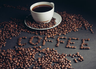 aromatic coffee beans and a drink in a cup gray background top view