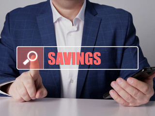  SAVINGS text in search bar. Businessman looking for something at cellphone. SAVINGS concept.