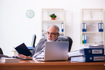 Old male businessman employee reading guidelines in the office