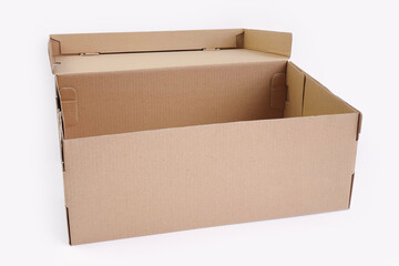 Open brown cardboard shoes box with lid for shoe or sneaker product packaging mockup, isolated on white background with clipping path. Craft paper box. Front view.