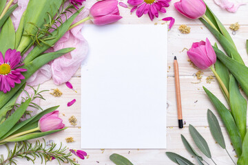 Tabletop scene with blank paper and a pen with pink flowers