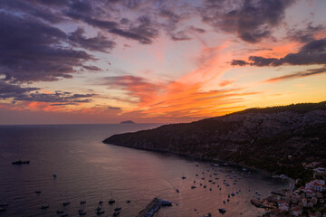 Aerial drone shot of sunset burning sky clouds on Komiza town over Vis Island in Croatia Summer
