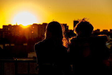 A couple is watching the sunset over the city from the observation deck in Warsaw, Poland