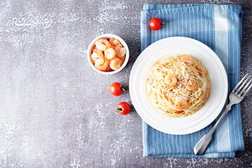 Garlic shrimp pasta in white plate with glass of wine