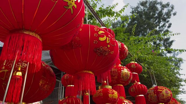 Slowmotion shot of colorful red and golden Chinese lanterns sold on an Asian street market prior to the Tet holiday or Lunar new year in Asia. TET concept. Travel to Asia. Letterings on lanterns and