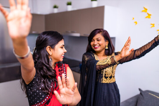 happy indian sisters are dancing together in new light apartment with design repair moving concept house