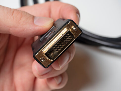 The DVI cable is black in the male hand. Cable for transmitting video images to digital display devices.