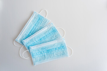 Three blue medicine masks lay  in a center of a white backgound.