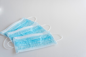 Three blue medicine fabric protective masks lay on a white backgound. Place for text.