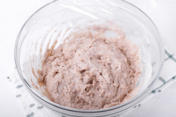 Rye and wheat flour mixed with yeast, sugar and milk in the glass bowl. Preparing the dough. Step by step recipe of crepes with rye flour. Step 2