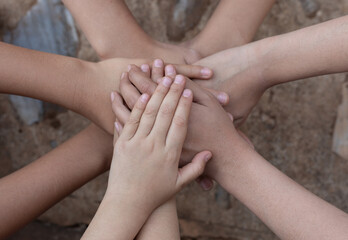 Close up top view of children hands putting their hands together. Stack of hands. Unity and...